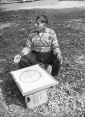 Seminole Indian Medicine Man Josie Billie sitting in chair in front of a Wheel of Life