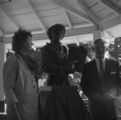 Man and woman standing by statue