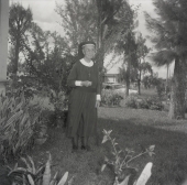 Deaconess Harriet Bedell standing in front yard of the Glade Cross Mission