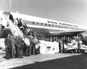 Passengers pose with flags on the inaugural flight for Miami to Lisbon