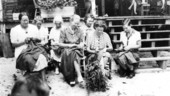 Women sewing in front of a porch