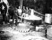 Sheriffs destroying distillery equipment.
