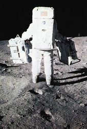 Buzz Aldrin carrying lunar seismometer and laser reflector equipment