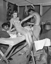 Makeup fitting actress Ann Blyth's tail during filming of movie.