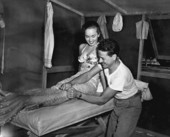 Getting actress Ann Blyth into her mermaid's tail during filming of movie.