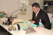 Senator Rudy Garcia examining materials at Mission San Luis during Senate Committee tour - Tallahassee, Florida.
