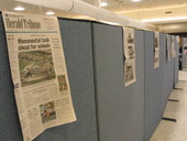 Daily newspaper stories on outside of cubicle walls.