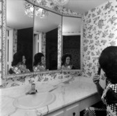 Unidentified woman fixing her hair in front of a mirror - Fort Lauderdale, Florida.