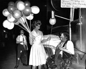 June Murphy handing balloon to clown in New York City during Florida promotion at the circus.