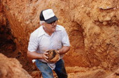State Archaeologist Calvin Jones carrying a recovered cannon ball from an excavation site in Tallahassee, Florida.