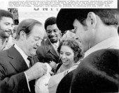 Hubert Humphrey signing a fan's arm cast at the Tallahassee airport.