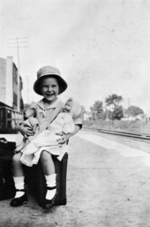 Mary Call Darby sitting on a suitcase.