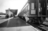 Woman stepping on "the Orange Blossom Special" train at railroad depot - Sebring, Florida.
