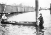 People in boat at flooded railroad yard - Chattahoochee, Florida.