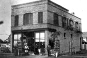Unidentified people standing in front of a brick building - Tavares, Florida.