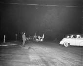 Ku Klux Klansmen in costume, riding in automobiles