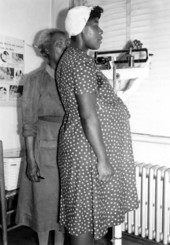 Expectant mother being weighed by a nurse during exam in Leon County, Florida.