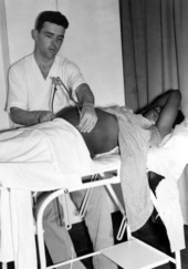 Dr. Coughlin, Director of the pre-natal clinic, taking measurements of a patient with calipers during an exam.