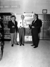 F. Wilson Carraway and unidentified men sample Cokes from the machine