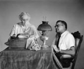 E.I Doss watches as an unidentified woman uses a hand cranked sewing machine - Tallahassee, Florida