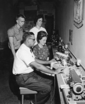 E.I. Doss demonstrates a sewing machine for the customers - Tallahassee, Florida