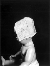 Antique handmade baby bonnet on a model