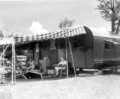 Mr. and Mrs. H. B. Straight sitting under the awning by their trailer - Sarasota, Florida .