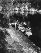 Von Walker loads boat with supplies on the shore of the Suwannee River .