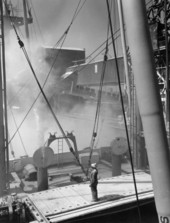Telescopic chute is lowered into cargo hold to load ship..