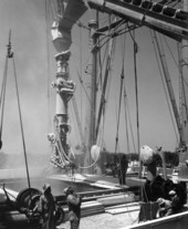 Telescopic chute is lowered into cargo hold to load ship..