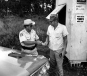 Supervisor "Skeeter" Thompson selling an unidentified hunter a permit - Dade County, Florida