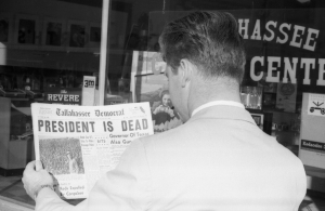 Edsel Dozier reading about President Kennedy's assassination in the newspaper.